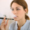 Portrait of woman smoking with electronic cigarette